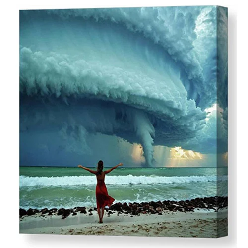 Digital artwork canvas print of a woman in a red dress stands on a beach with her arms outstretched, facing an approaching storm with massive, swirling clouds.